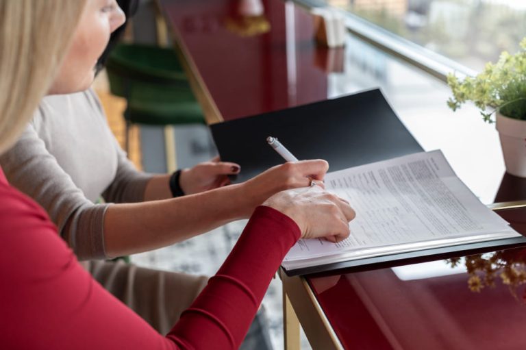 una mujer firmando una escritura de compraventa