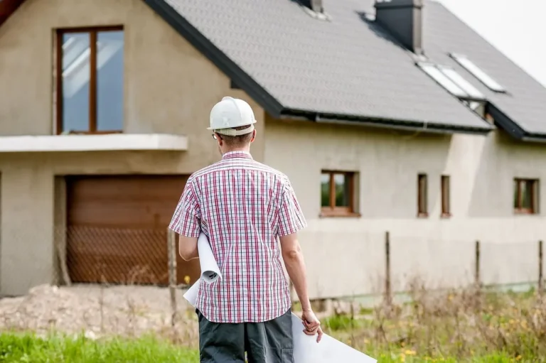 Arquitecto viendo una casa y un certificado final de obra en la mano