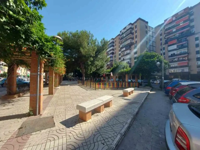 Jardín infantil con bloques de edificios detrás en el Barrio de Santa Aurelia Sevilla