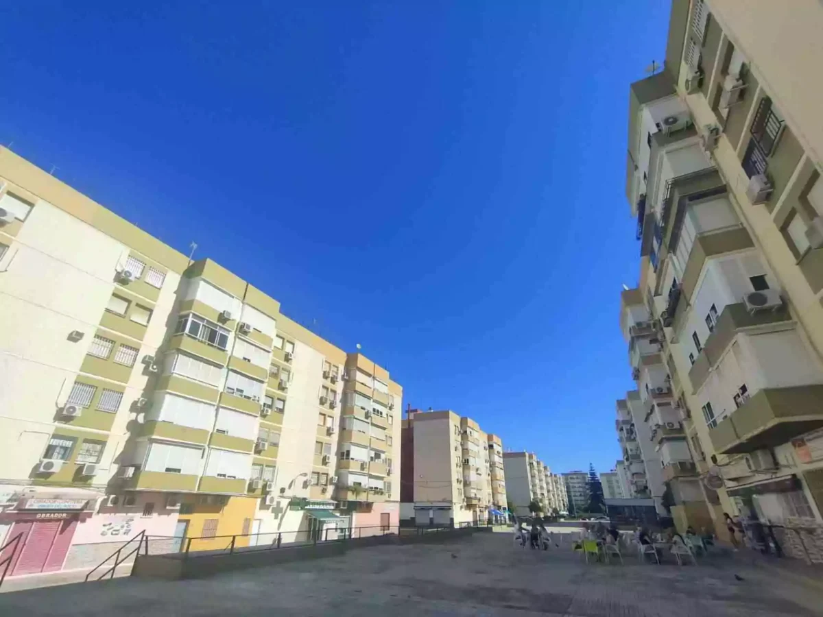 Patio interior con edificios residenciales en el barrio de Los Príncipes Sevilla, bajo un cielo despejado.