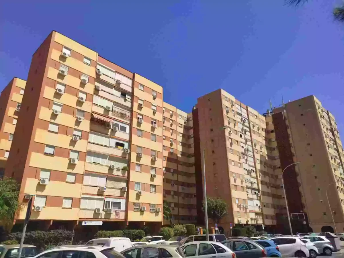 Edificios residenciales del barrio de San Diego, Sevilla, con cielo despejado y coches estacionados.