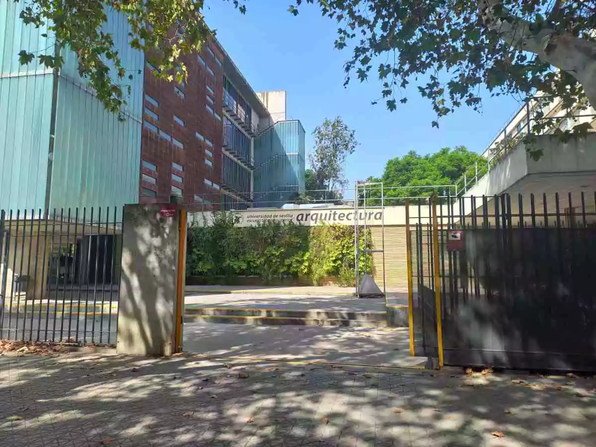 Centro universitario vallado con las puertas abiertas y un edificio de cristal a la izquierda