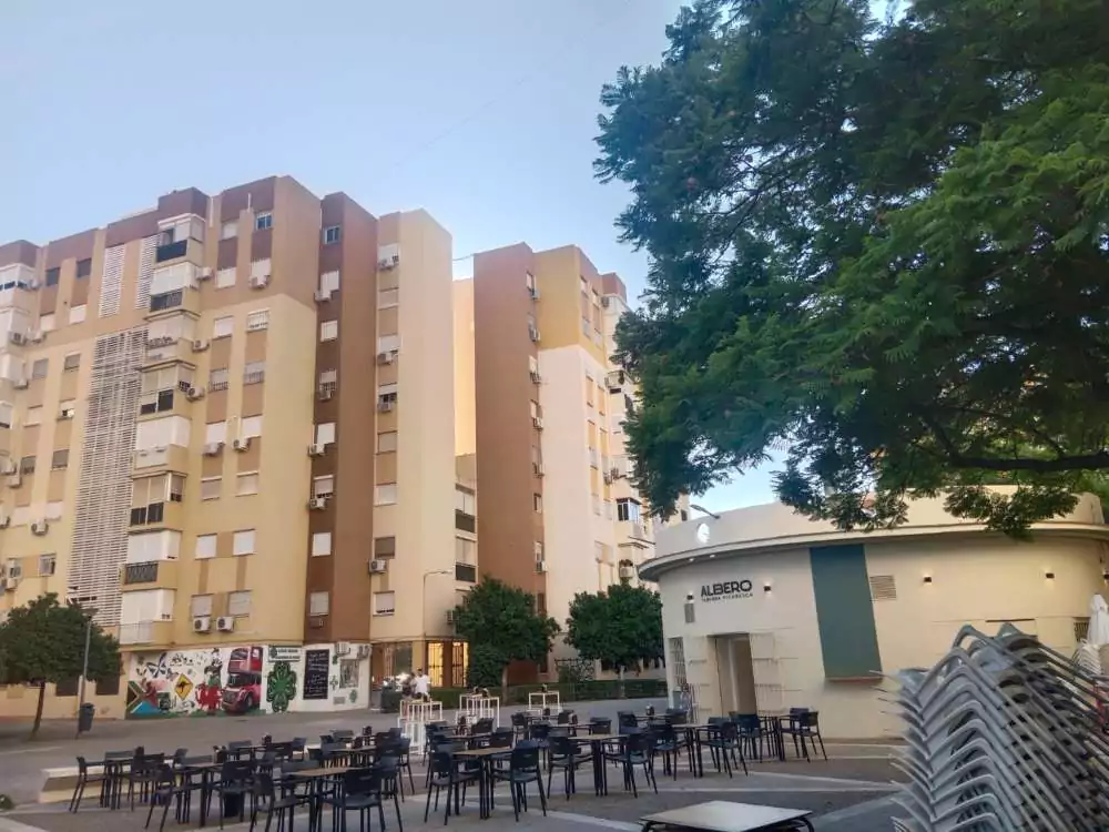 Bar en la barriada de las Almenas y bloques de pisos al fondo.