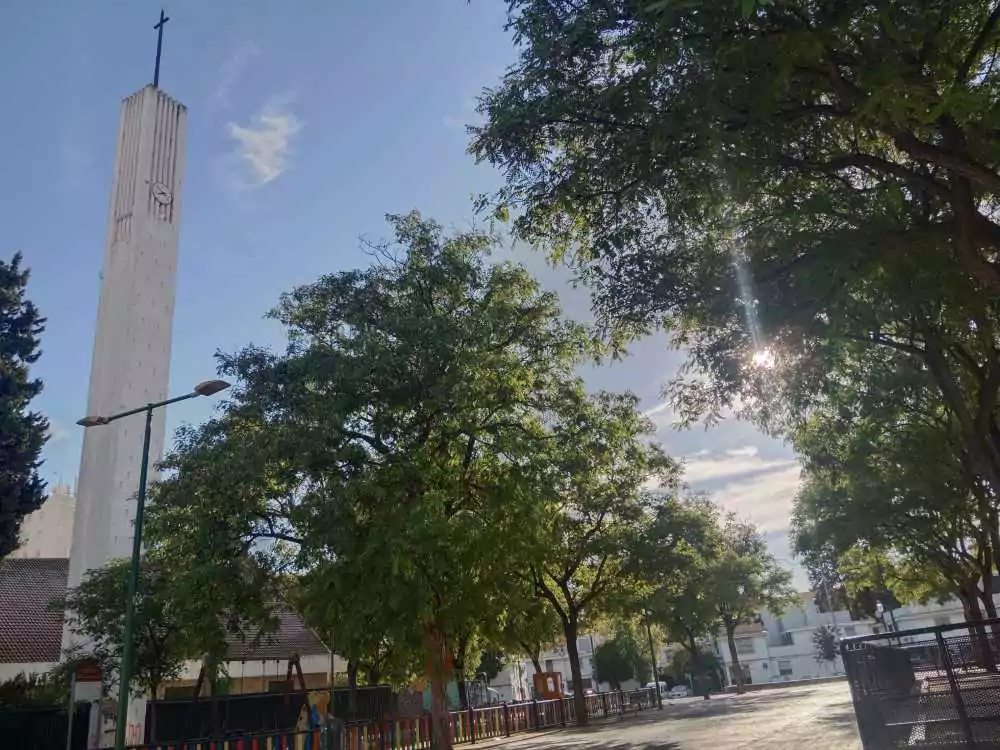 Torre de la iglesia con un frente de árboles