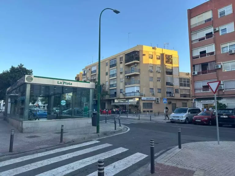 Parada de metro, edificios y árboles de La Plata en Sevilla