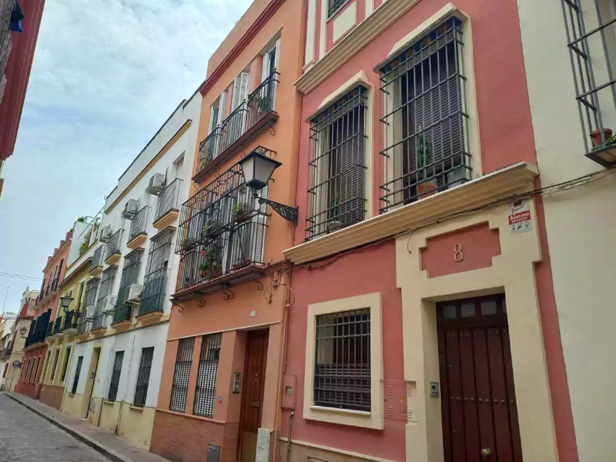 Edificios de tres pisos de alturas de diferentes colores terrosos, con rejas en las ventanas