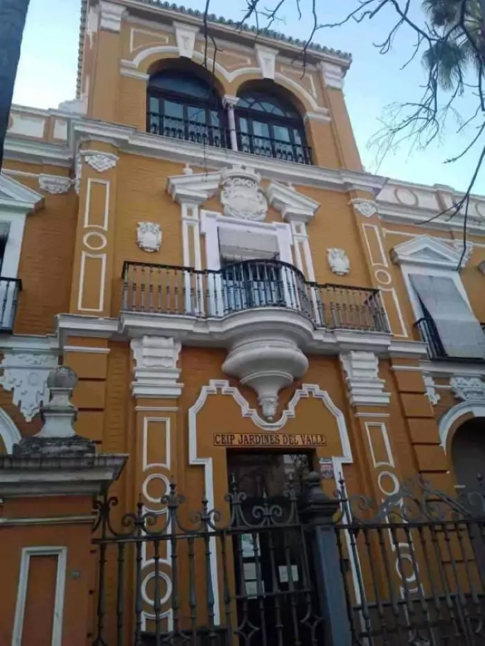 Colegio en el Barrio Santa Catalina, Sevilla. Fachada de color ocre y detalles blancos en molduras.